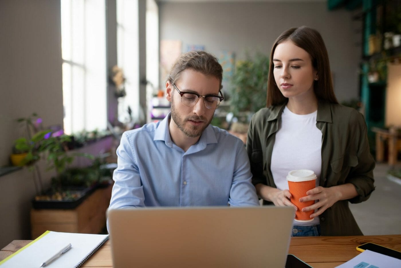 Young man and girl carefully looking at the laptop screen.