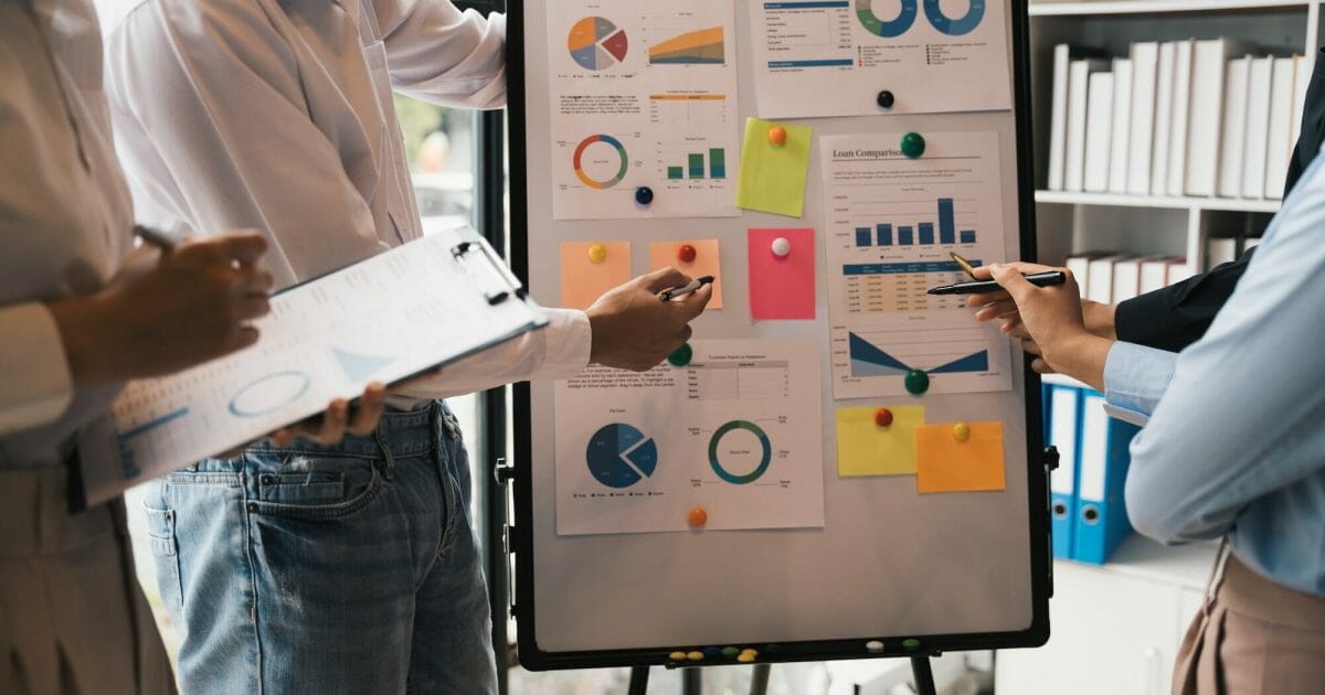 Business colleagues point and explaining to Monthly Budget, Financial and loan comparison on board,