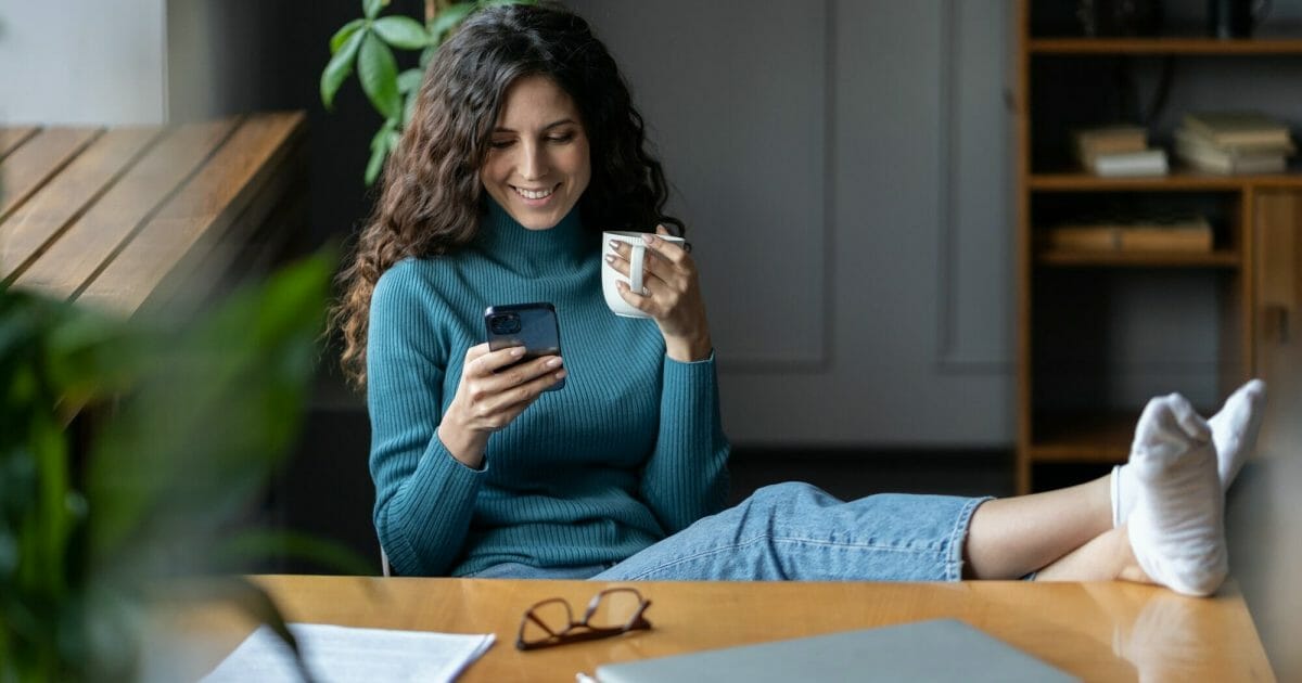 Remote worker girl procrastinate at workplace sit at desk with closed laptop chat in social media