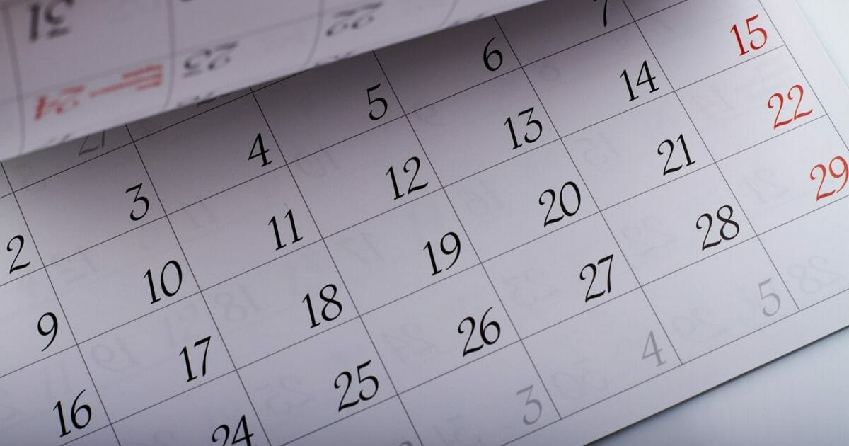 Turning month calendar page sheets with dates closeup-up.