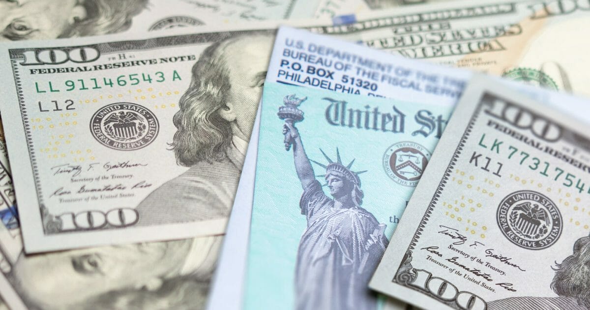 United States IRS Check and Envelope Resting on Money