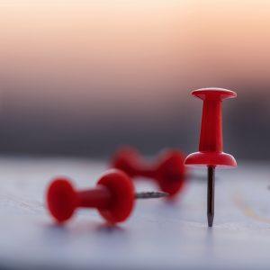 Close up red pin push map under sunset background. business focus and target concept.